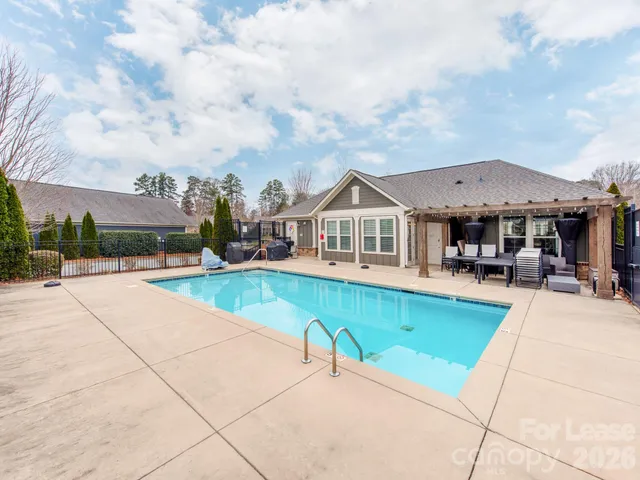 a view of a house with swimming pool and sitting area