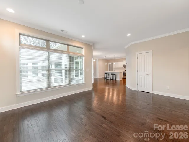 a view of empty room with wooden floor and window