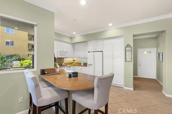 a kitchen with a table chairs refrigerator and cabinets
