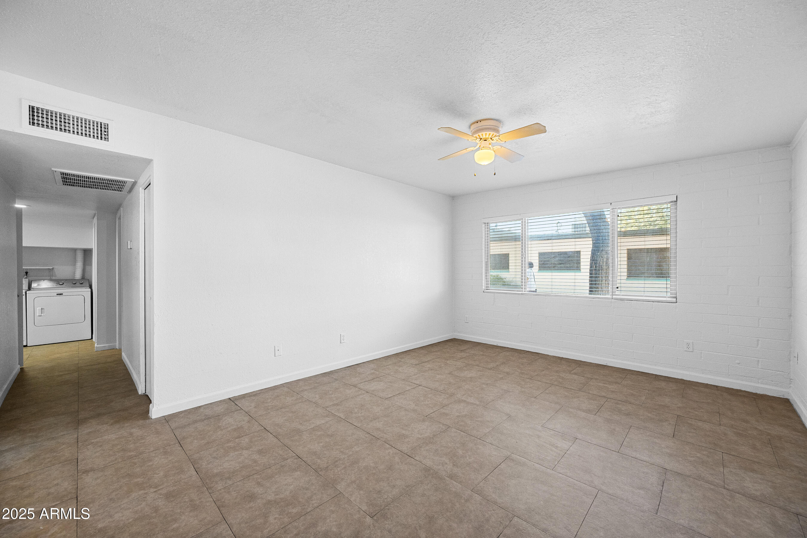 1518 West Colter Street, Unit 9 Phoenix, AZ 85015 - Photo 3 of 26 an empty room with windows and chandelier fan
