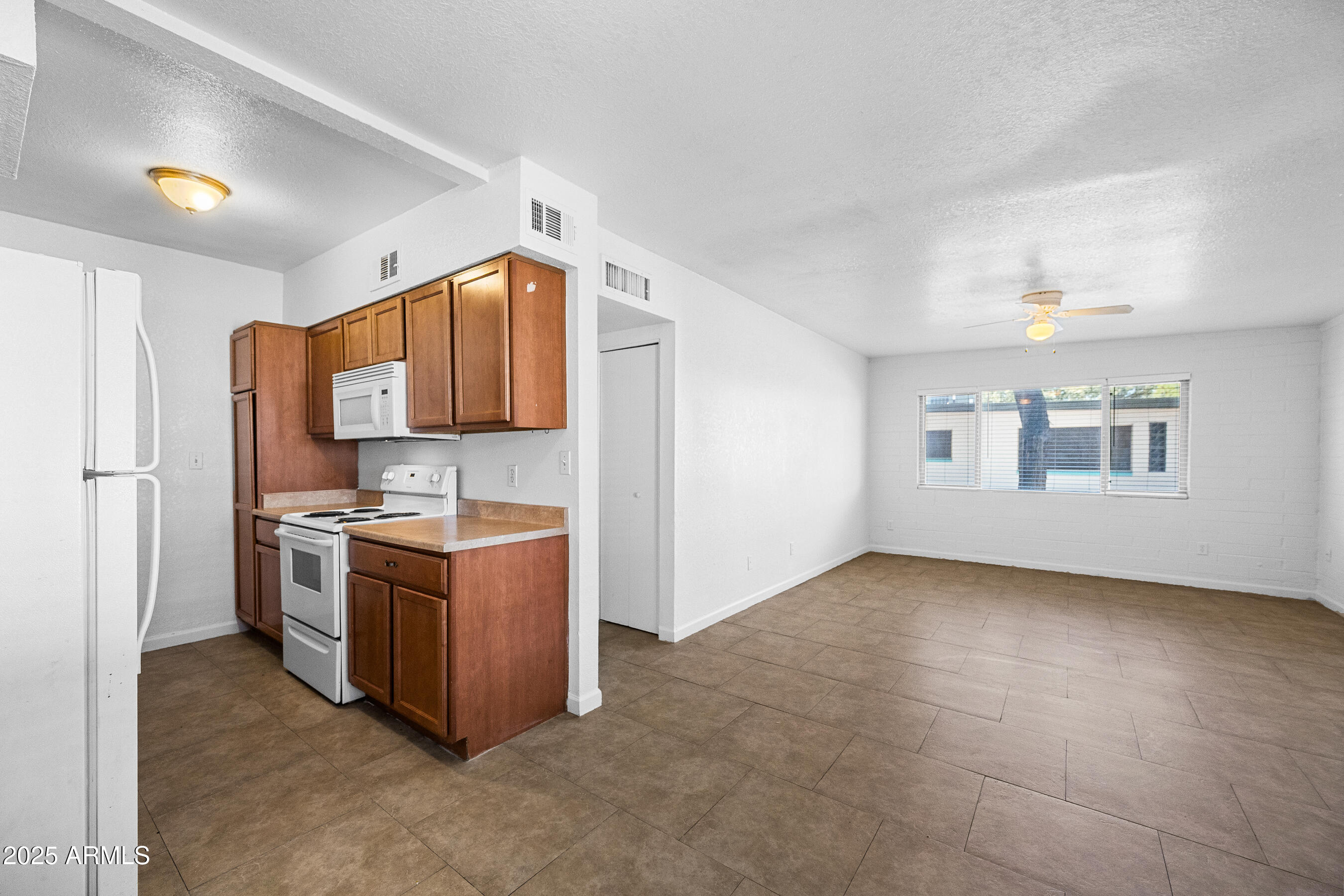 1518 West Colter Street, Unit 9 Phoenix, AZ 85015 - Photo 6 of 26 a kitchen with stainless steel appliances granite countertop a stove and a refrigerator