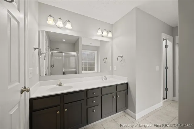 a bathroom with a double vanity sink and mirror with shower
