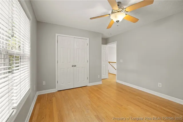 a view of a big room with windows and chandelier fan