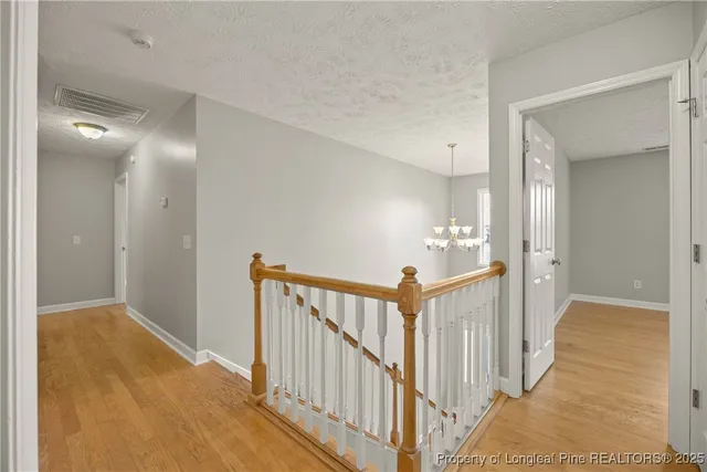 a view of a hallway view with wooden floor and staircase