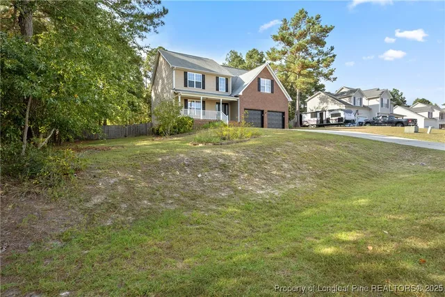 a front view of a house with a garden and trees