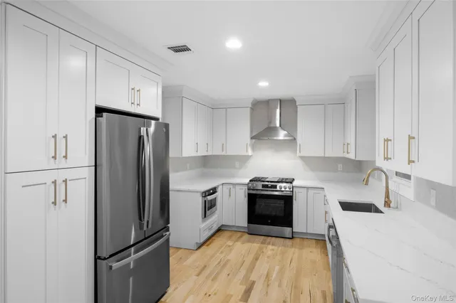a kitchen with stainless steel appliances a refrigerator sink and stove