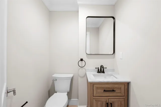 a bathroom with a toilet a sink and mirror