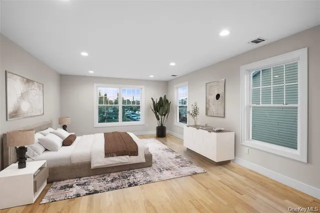a living room with furniture large window and wooden floor