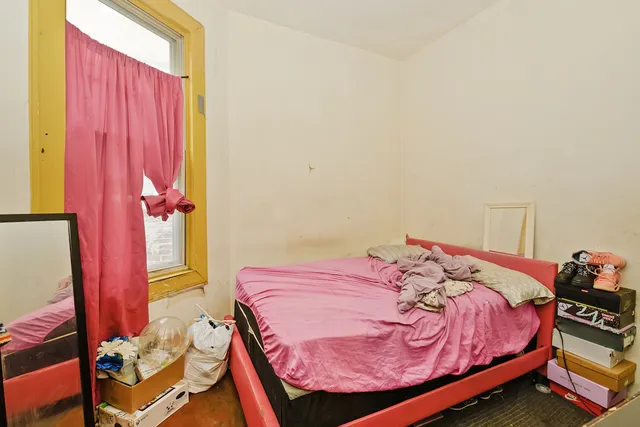 a bed sitting in a bedroom next to a window