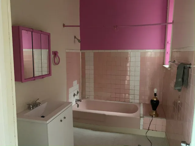 a bathroom with a bathtub sink vanity and toilet