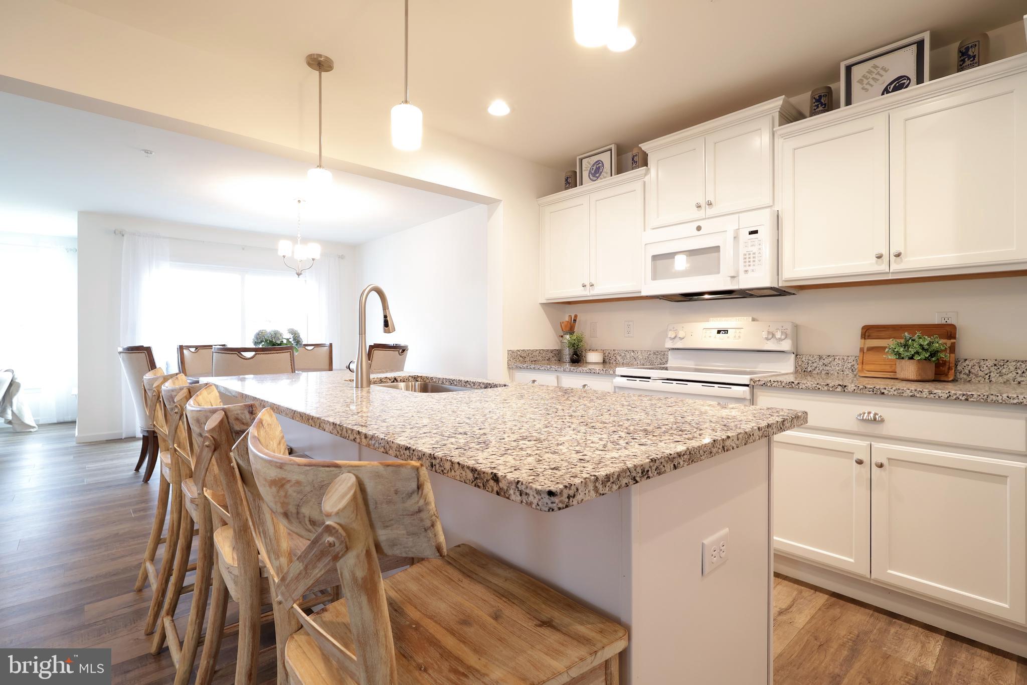 154 Magnolia Lane State College, PA 16803 - Photo 7 of 60 a kitchen with stainless steel appliances granite countertop a sink a stove a refrigerator and white cabinets with wooden floor