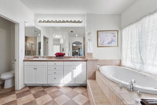 a spacious bathroom with a granite countertop sink mirror and bathtub