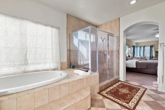 a spacious bathroom with a tub shower and a sink
