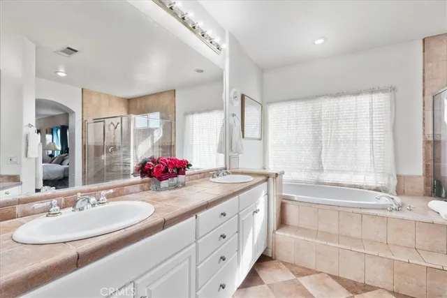 a bathroom with a granite countertop sink mirror and a bathtub