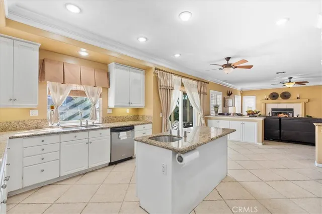 a kitchen with granite countertop a sink and white cabinets