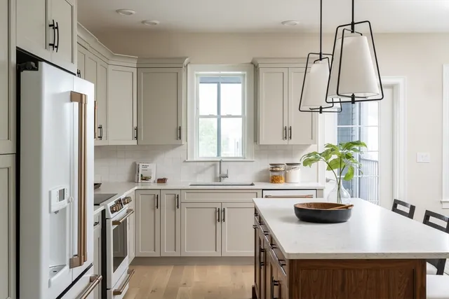 a kitchen with stainless steel appliances a sink a stove a refrigerator and cabinets