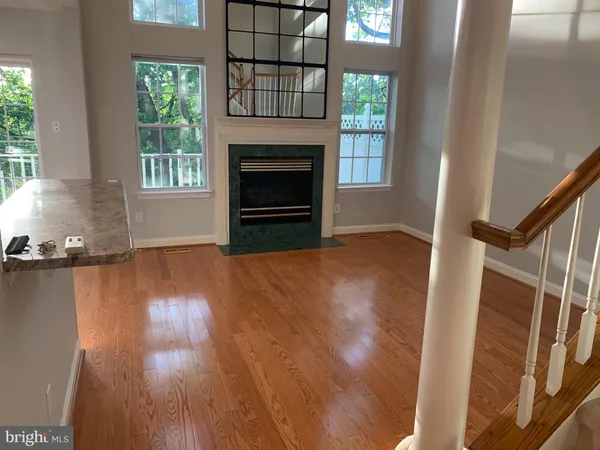 a view of empty room with wooden floor and fireplace