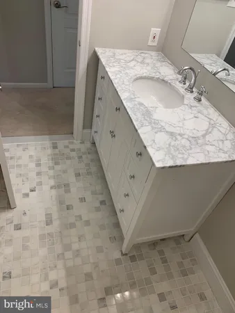 a bathroom with a granite countertop sink and a mirror