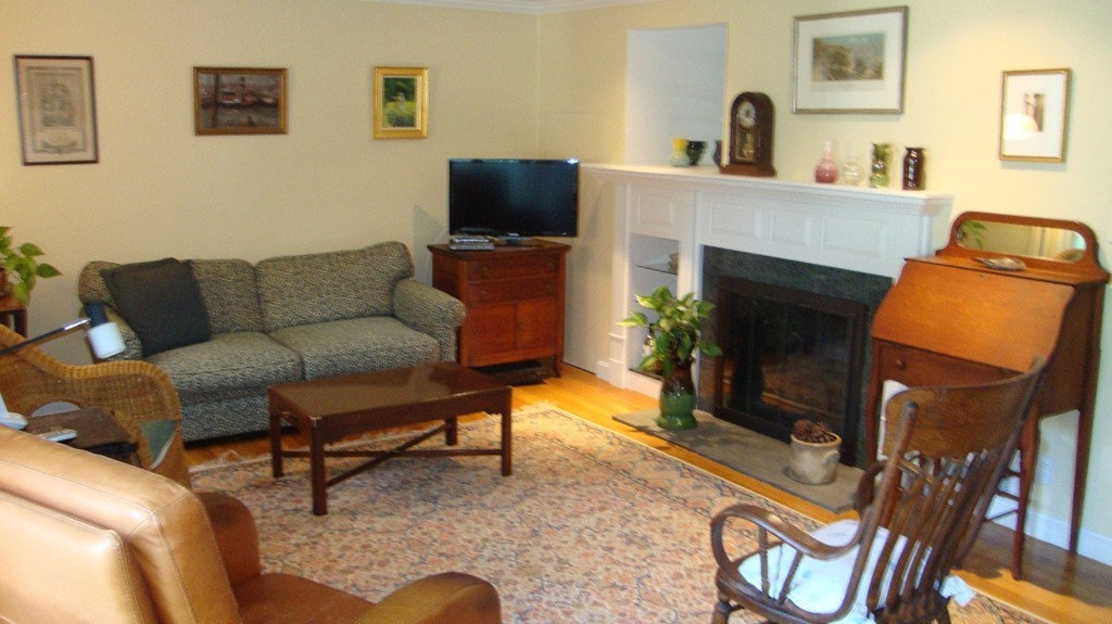 112 Jericho Road, Unit 112 Weston, MA 02493 - Photo 3 of 17 a living room with furniture a flat screen tv and a fireplace