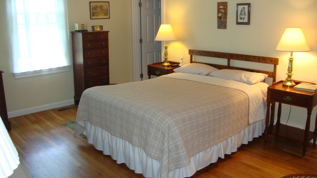 112 Jericho Road, Unit 112 Weston, MA 02493 - Photo 9 of 17 a bedroom with bed and wooden floor
