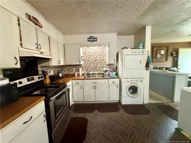 a kitchen with a white stove top oven sink and cabinets