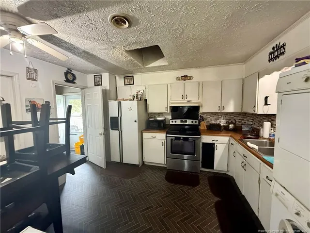 a kitchen with stainless steel appliances granite countertop a refrigerator a stove top oven a sink and dishwasher