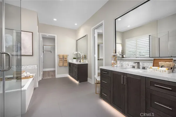 a spacious bathroom with a double vanity sink a mirror and shower