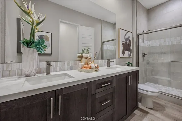 a bathroom with a granite countertop sink a toilet a mirror and shower