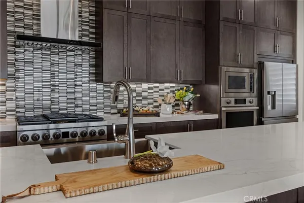 a kitchen with stainless steel appliances a stove a microwave a sink and cabinets