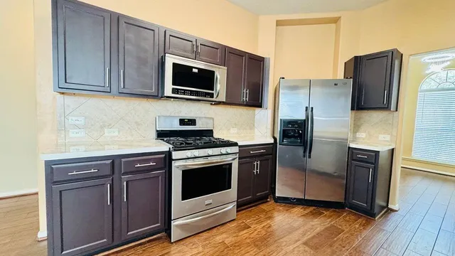 a kitchen with stainless steel appliances granite countertop a refrigerator microwave and sink