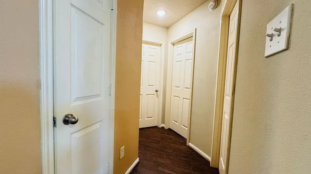 a view of a hallway with wooden floor
