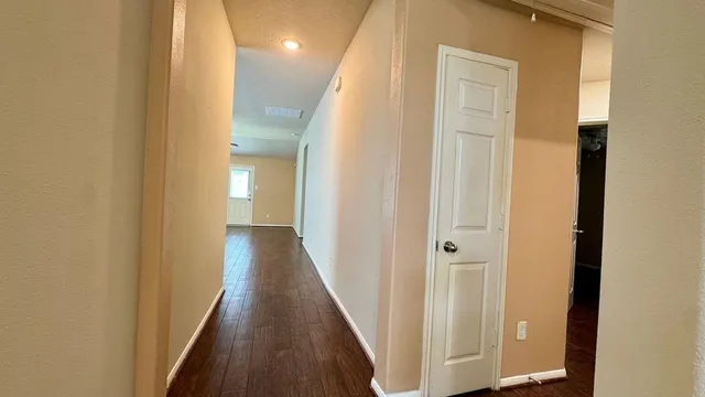 a view of a hallway with wooden floor