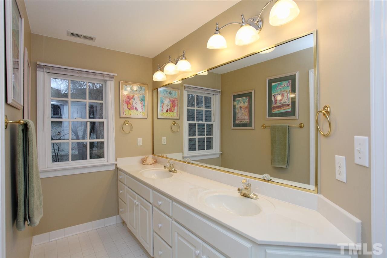 1405 Silverling Way Raleigh, NC 27613 - Photo 18 of 25 a bathroom with a tub a sink and a large mirror