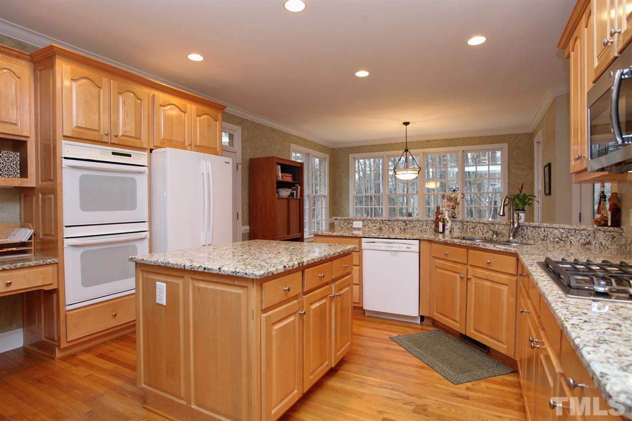 1405 Silverling Way Raleigh, NC 27613 - Photo 8 of 25 a kitchen with stainless steel appliances granite countertop a kitchen island a stove a sink and a refrigerator