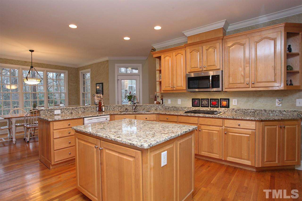 1405 Silverling Way Raleigh, NC 27613 - Photo 9 of 25 a kitchen with stainless steel appliances granite countertop wooden cabinets a sink a stove a dining table and chairs