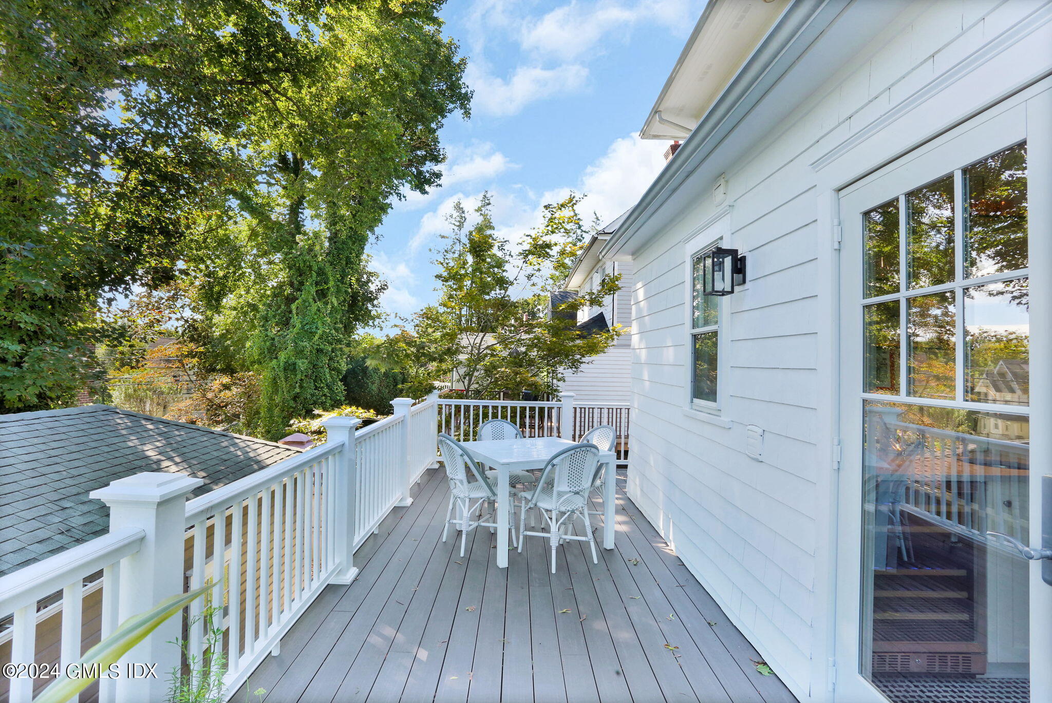 53 Ridge Street Greenwich, CT 06830 - Photo 18 of 26 a view of a roof deck with table and chairs and wooden floor