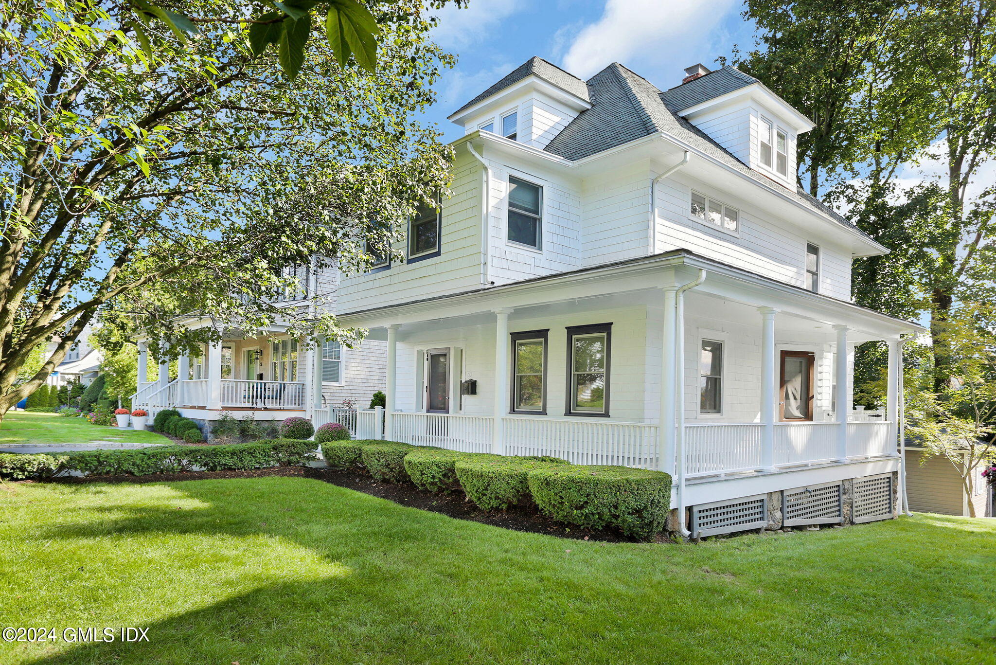 53 Ridge Street Greenwich, CT 06830 - Photo 2 of 26 a front view of a house with a yard and potted plants
