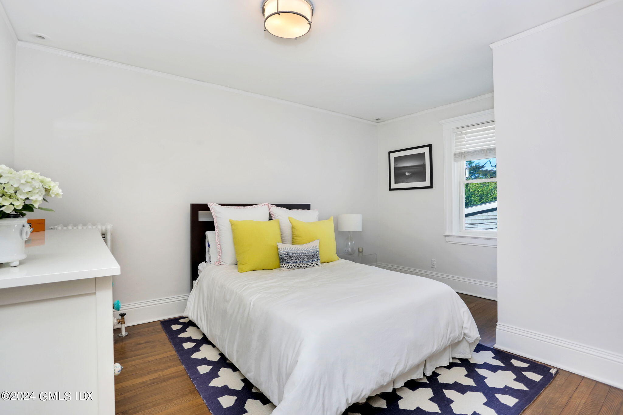 53 Ridge Street Greenwich, CT 06830 - Photo 23 of 26 a bedroom with a bed and wooden floor