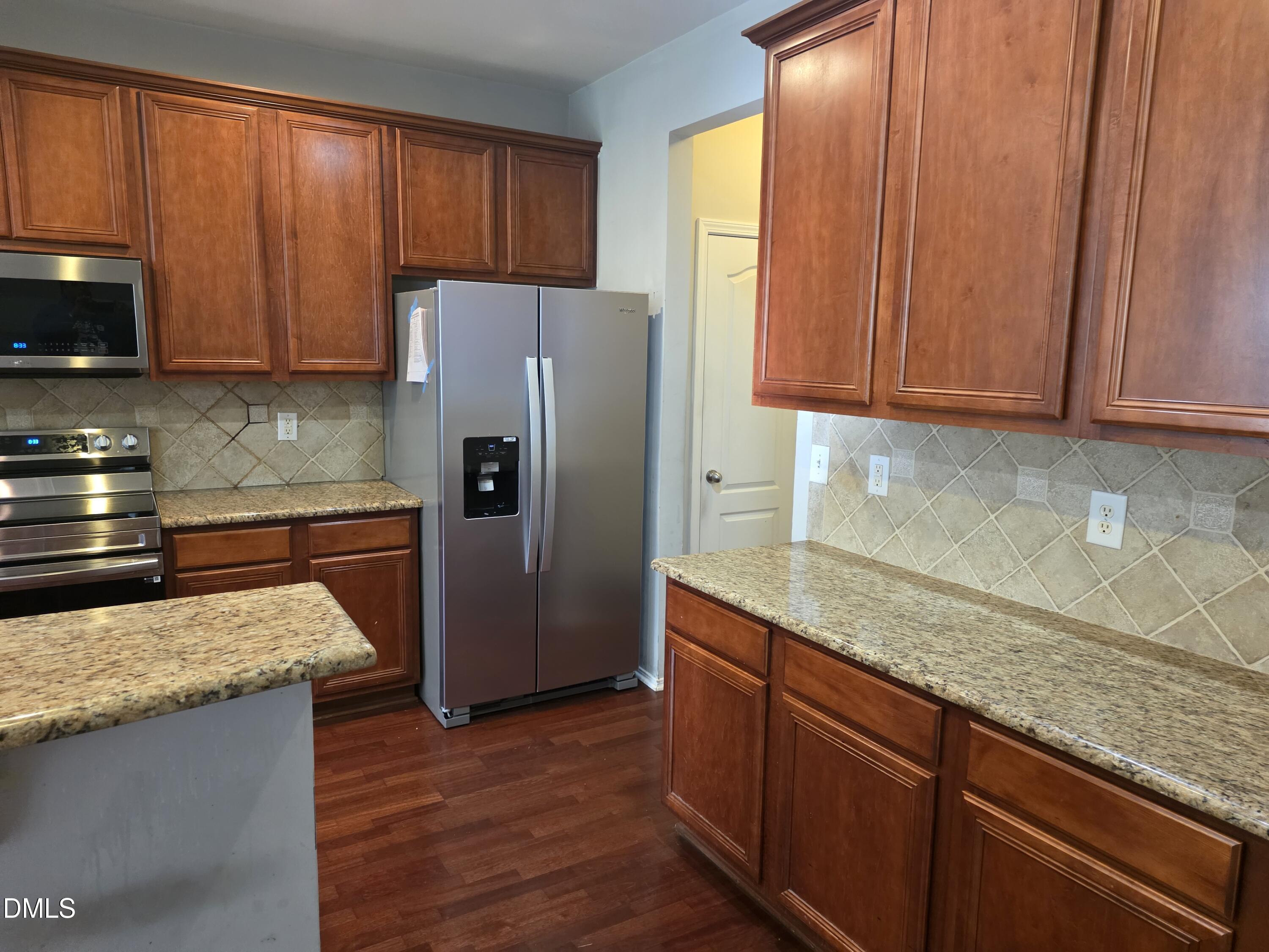 8208 Stone Cellar Drive Raleigh, NC 27613 - Photo 2 of 25 a kitchen with stainless steel appliances granite countertop a refrigerator sink and cabinets