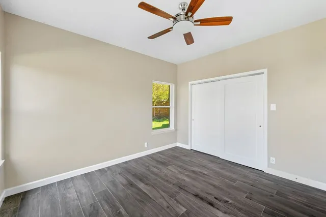 a view of empty room with wooden floor