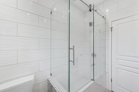 a bathroom with a shower and a glass door