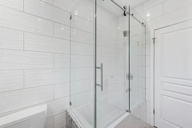 a bathroom with a shower and a glass door