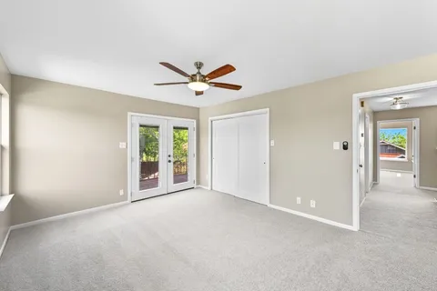 an empty room with fan and windows