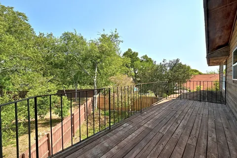 a view of balcony with wooden floor and fence