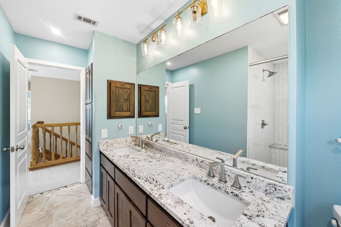 1904 Cedar Ridge Drive Austin, TX 78741 - Photo 33 of 40 a bathroom with a granite countertop double vanity sink and mirror