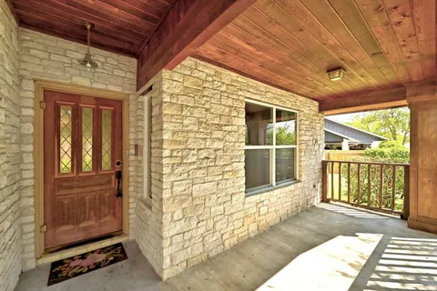 a view of a porch with a table and chairs