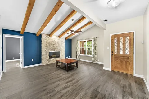 a view of a livingroom with wooden floor and furniture