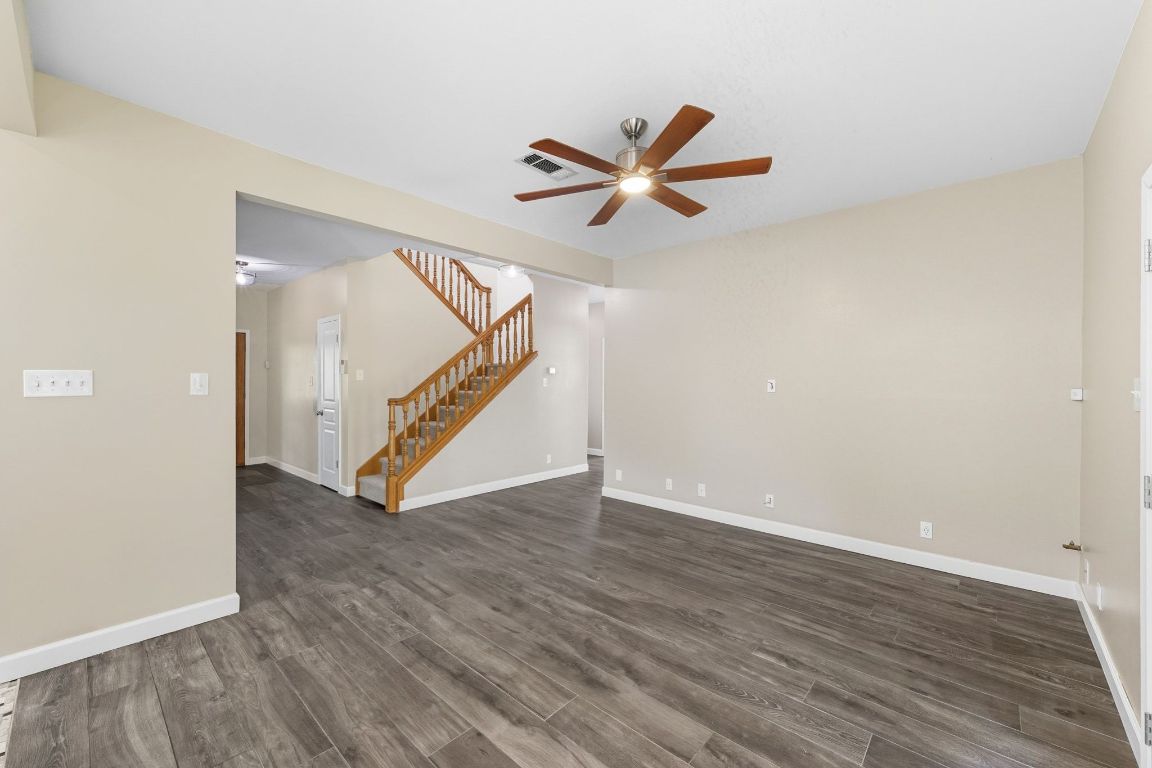 1904 Cedar Ridge Drive Austin, TX 78741 - Photo 9 of 40 a view of an empty room with wooden floor and a ceiling fan