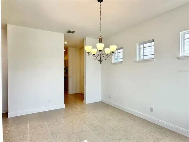 a view of a room with a chandelier fan and windows