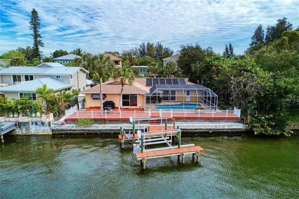 an aerial view of a house with swimming pool and lake view